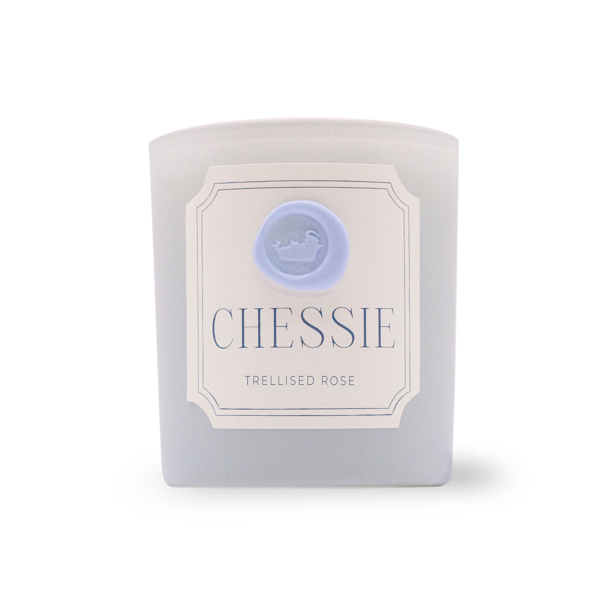 A frosted glass candle jar with a white label reading 'CHESSIE MORNING FOG' and a light blue circular logo, photographed on a white background.